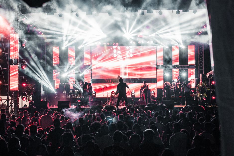 Energetic Afrobeats star performing live on stage with flashing lights in Lagos