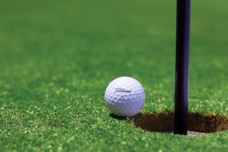 Golfer on a green course preparing to swing during a tournament