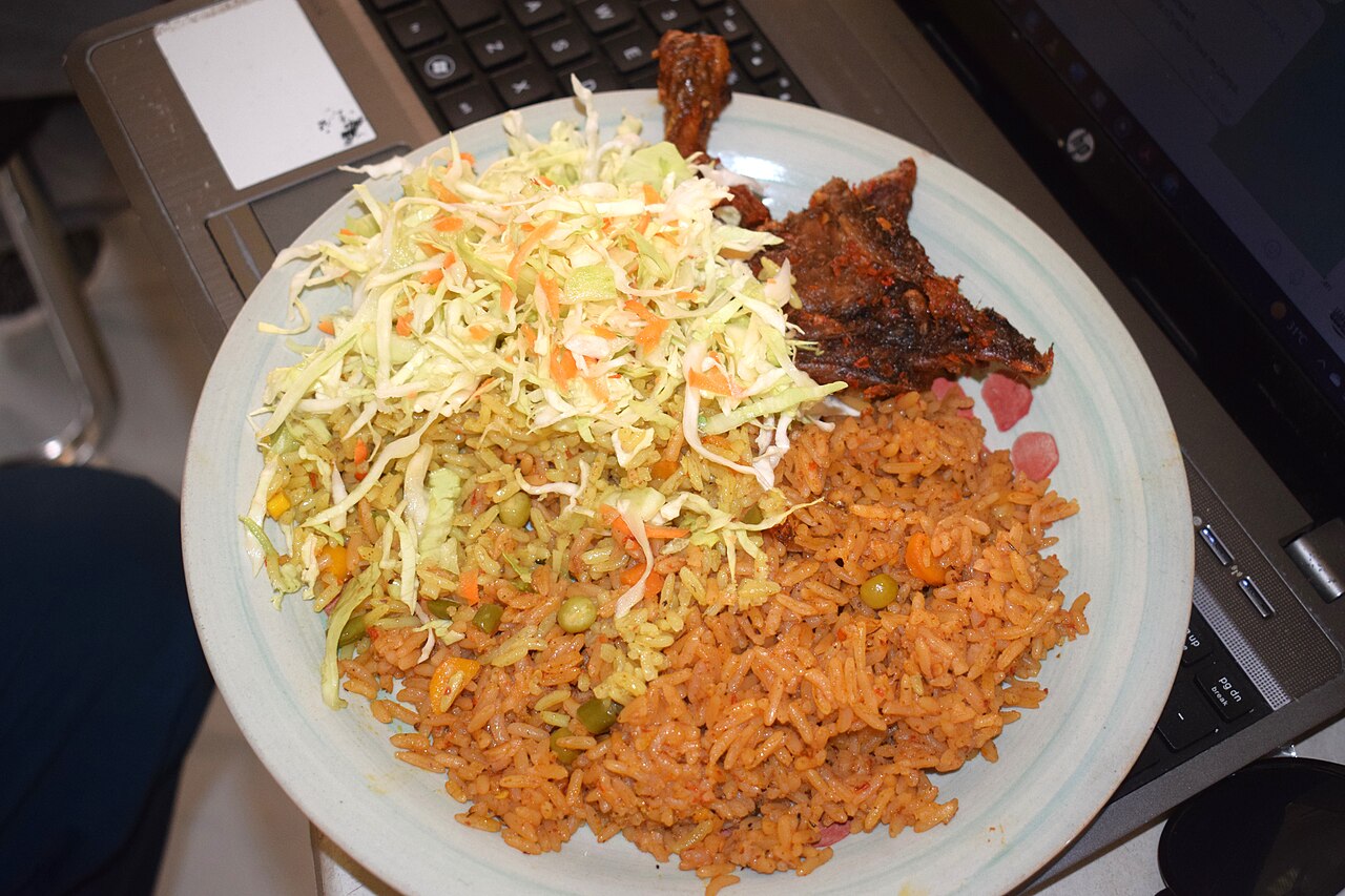 Delicious plate of Nigerian party jollof rice with fried plantain and meat