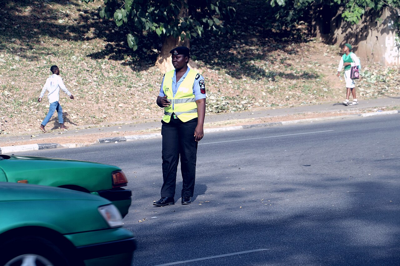 Nigerian police officers directing traffic and checking vehicle particulars in Abuja